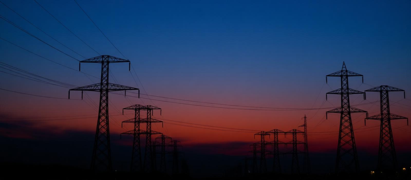 Electricity transmission towers and power lines at twilight representing utility infrastructure across the United States